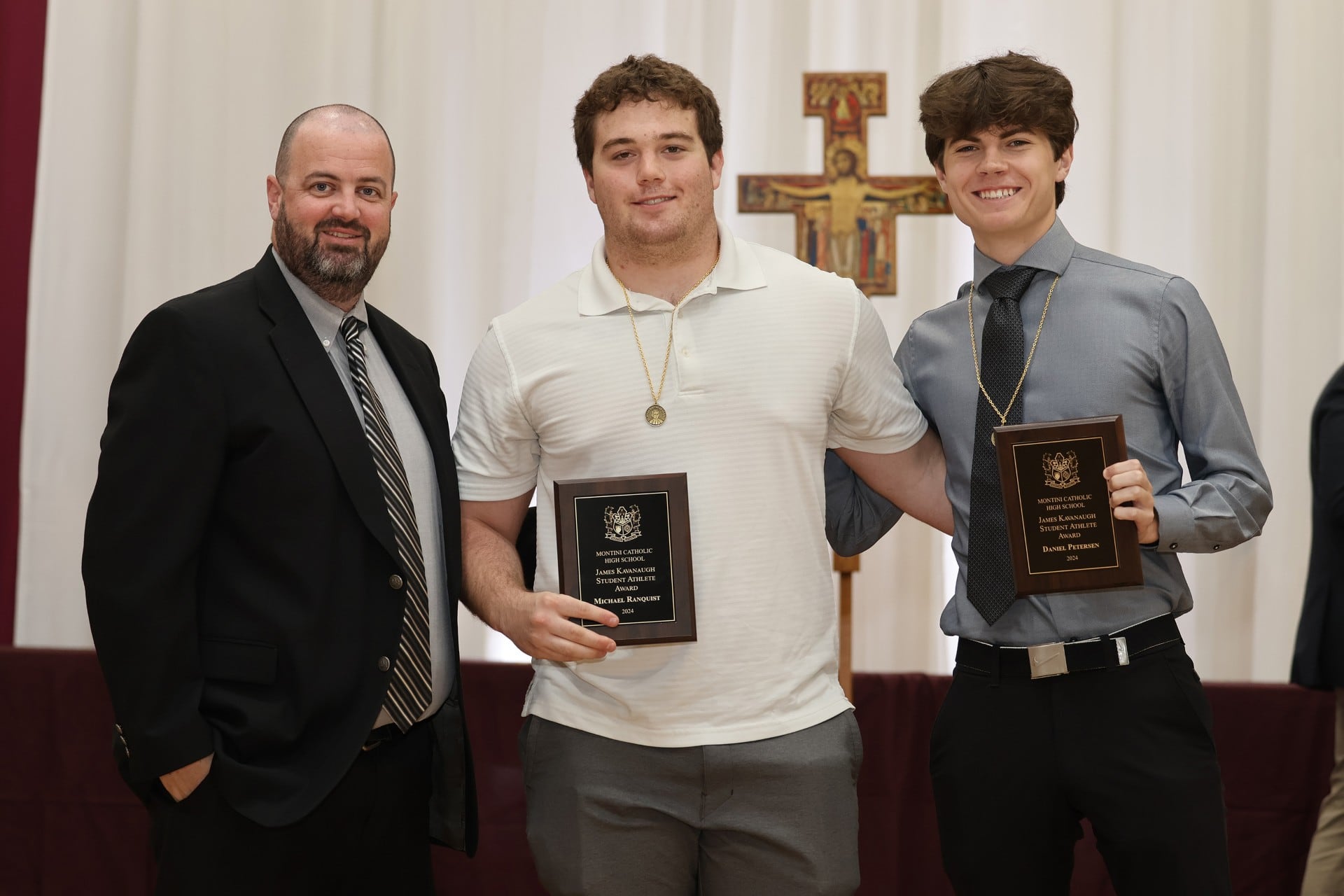 Montini Catholic High School seniors Mick Ranquist (center) and Danny Petersen (right) receive the James Kavanaugh Scholar/Athlete Award from Athletic Director Brian Casey at the school's Founders Day ceremony on May 17, 2024