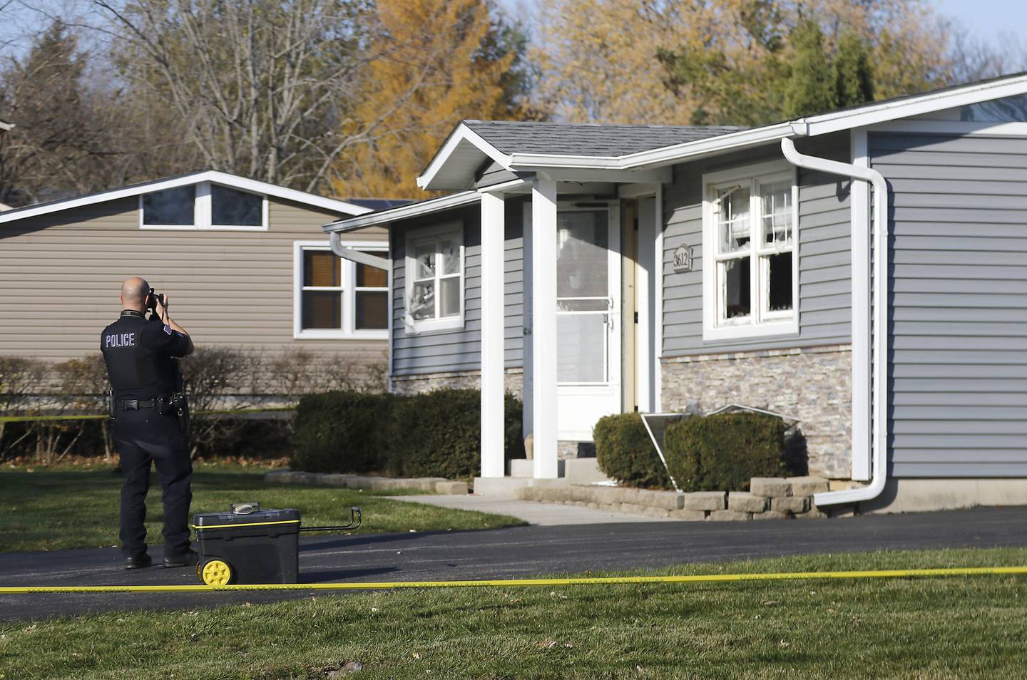 A Johnsburg police officer photographs damages to a home in the 3600 block of Fillmore Road on Wednesday, Nov, 15, 2023. Johnsburg Police officers were dispatched to the home at approximately 11:08 p.m. Tuesday, for a man allegedly shooting a gun inside the house.