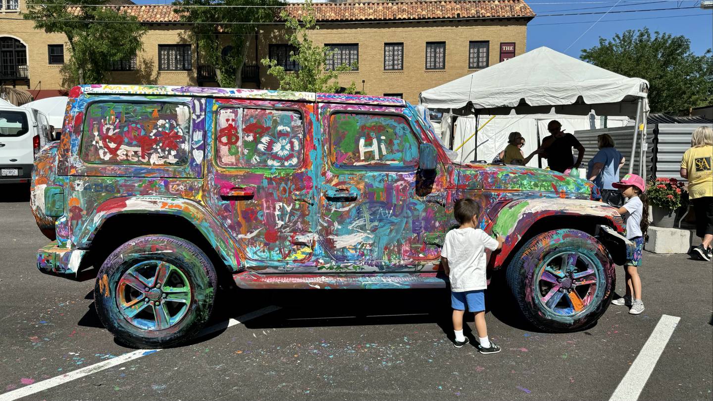 Young artists add their mark to a Jeep during the Paint a Car activity at the annual Fine Art Show on May 25 and 26, 2024, in downtown St. Charles.