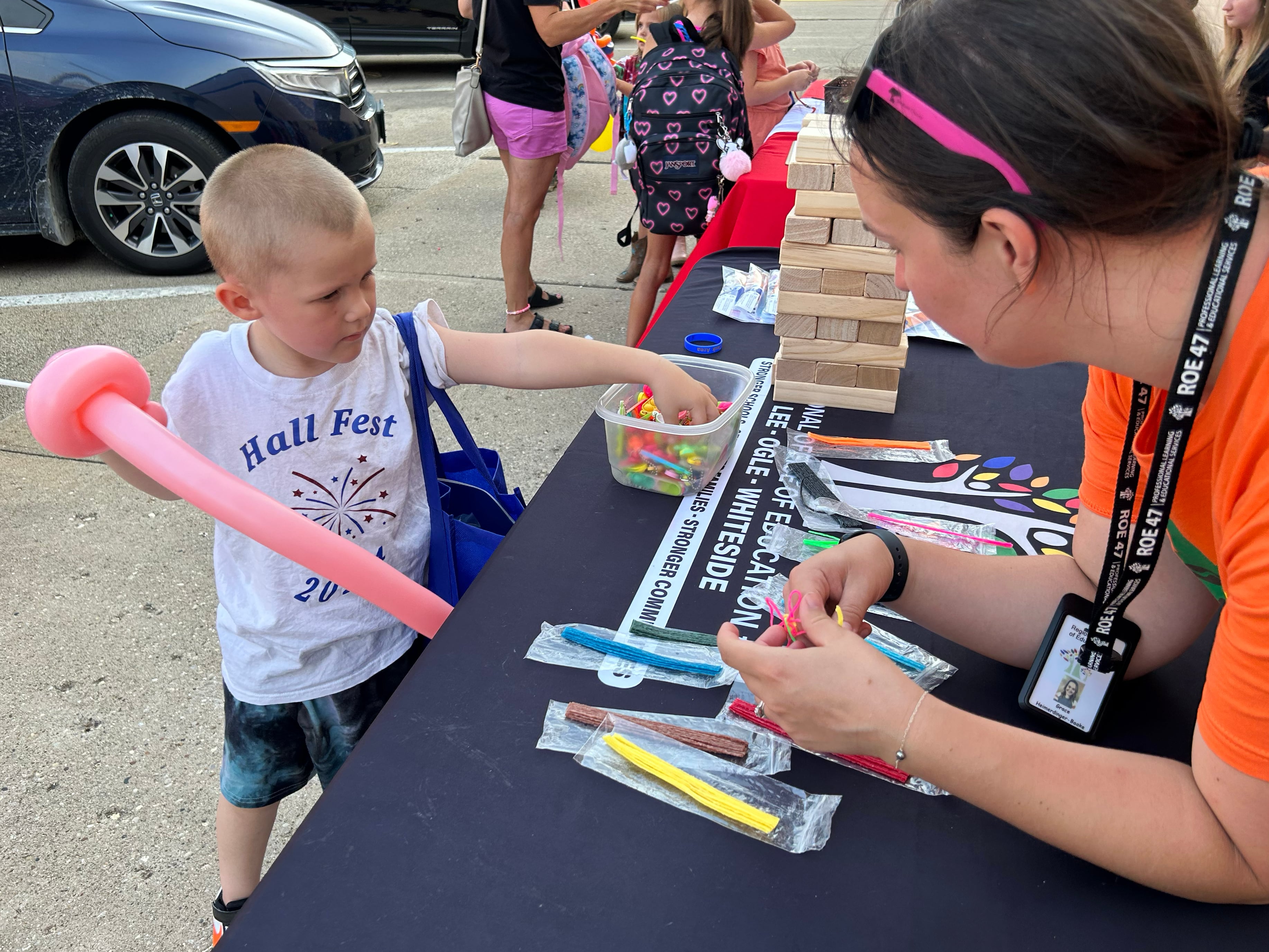 Thomas Tarbill, 5, of Lyndon, picks up an item as Grace Heimerdinger-Baake, of the Regional Office of Education 47, helps during Prophetstown's Fourth Friday on Friday, July 26, 2024. The ROE was one of the entities that handed out school supplies and other items during the event.