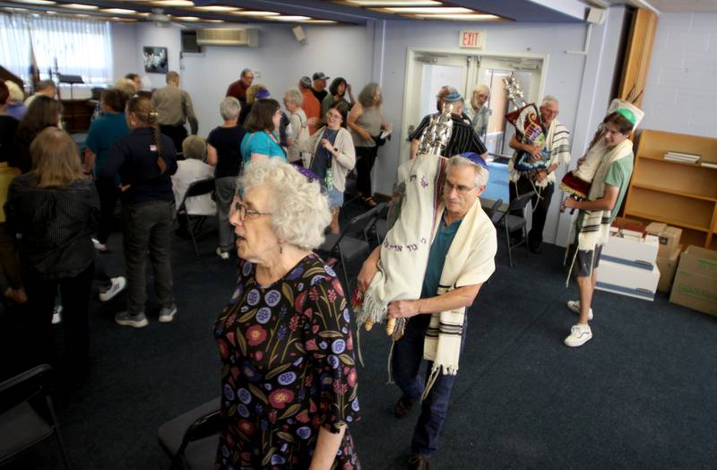 Torah Scrolls are marched from the building as the McHenry County Jewish Congregation held a deconsecration ceremony at their Ridgefield Road location in preparation for a move to the Tree of Life Unitarian Church in McHenry on Sunday, August 18. Mezuzot were removed from doorways and the Torah Scrolls were removed from their ark and transported  to the new building as worshipers consecrated the new building as their synagogue.