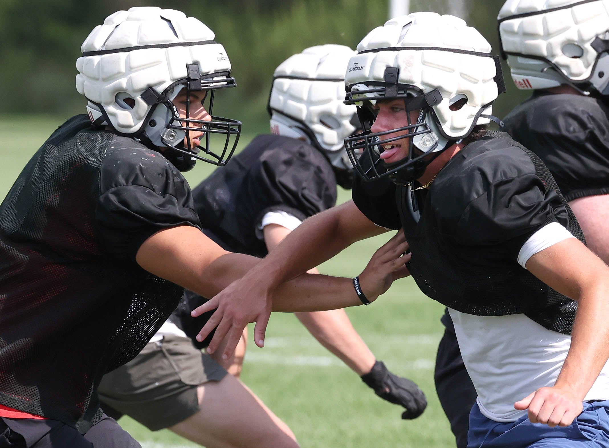 Kaneland’s Vinny McDonald (right) sheds a block in a punting drill during practice Friday, Aug. 16, 2024, at the school in Maple Park.