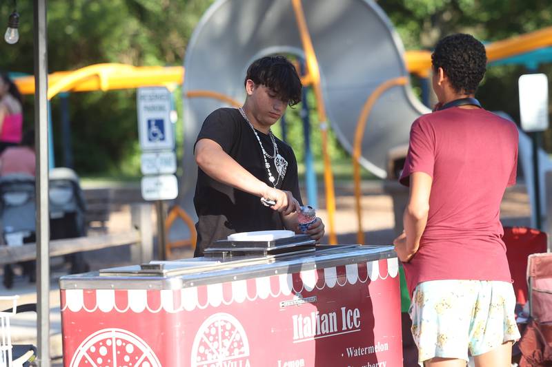 Dominic Burhans, of Villa Nova Pizza, serves Italian ice at Dellwood Park in Lockport on Wednesday July 3, 2024.