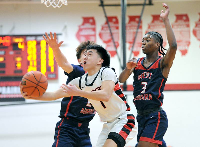 Bolingbrook's Josh Aniceto (1) takes a reverse layup in front of two West Aurora defenders during a class 4A regional championship basketball game at Yorkville High School on Friday, Feb. 23, 2024.