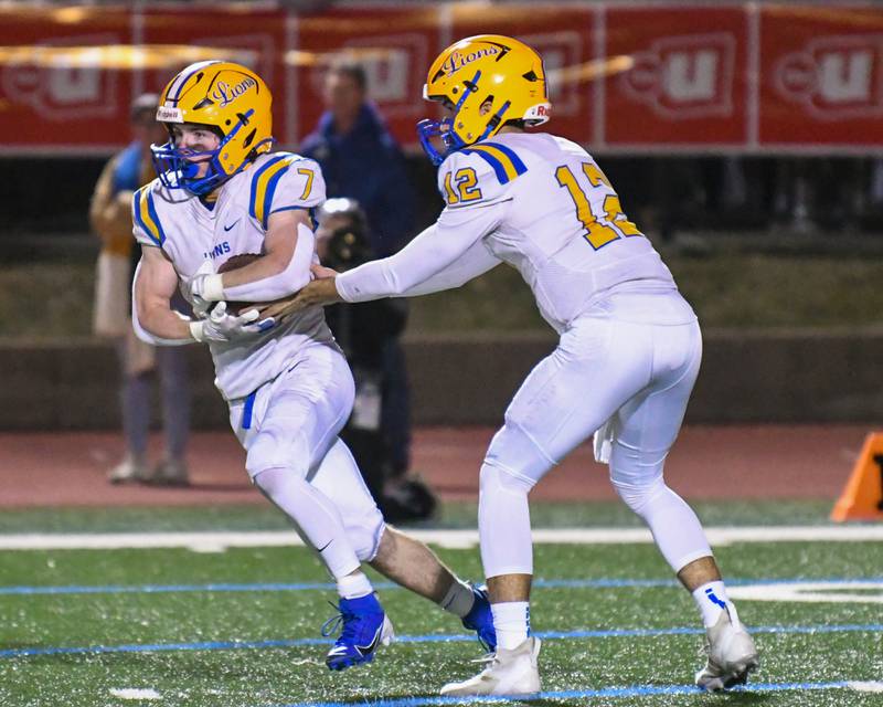 Lyons Township's Dom Pisciotti (12)hands the ball off to teammate Lyons Township's Danny Carroll (7) during the game on Friday Oct. 18, 2024, while traveling to take on York High School in Elmhurst.