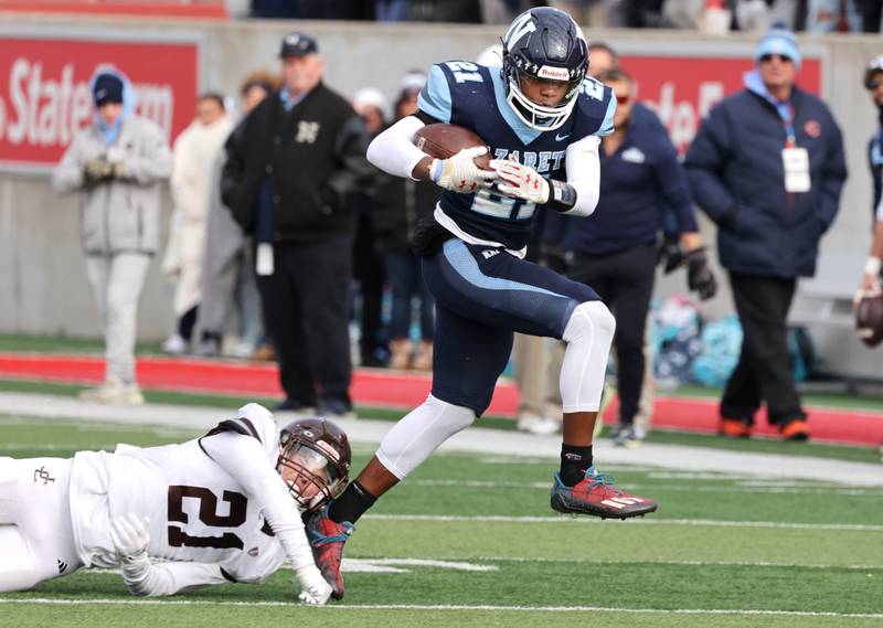 Nazareth's Lesroy Tittle breaks the tackle attempt of Joliet Catholic's Conner O’Donnell on his way to a touchdown Saturday, Nov. 25, 2023, during their IHSA Class 5A state championship game in Hancock Stadium at Illinois State University in Normal.