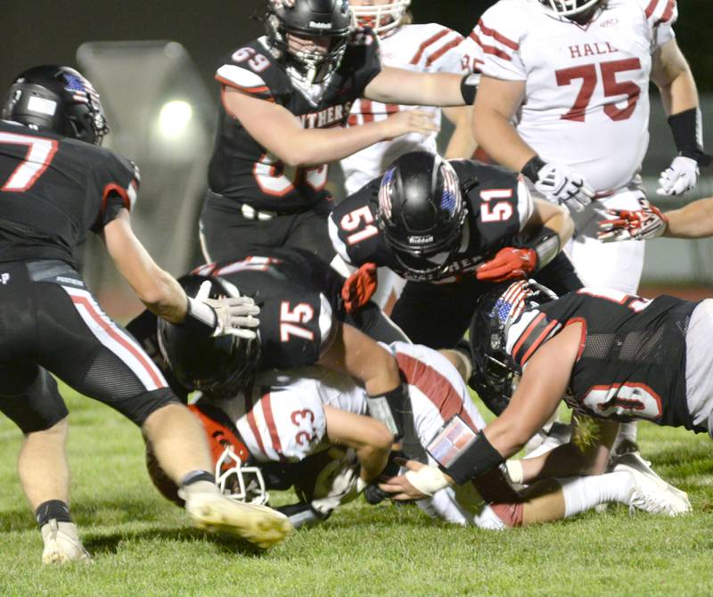 Erie-Prophetstown linemen Caleb Reymer (75), Derek Naftzger (51), and Amen Barron (50) tackle Hall's Jack Curran (23) during a Friday, Sept. 6, 2024 game in Prophetstown.