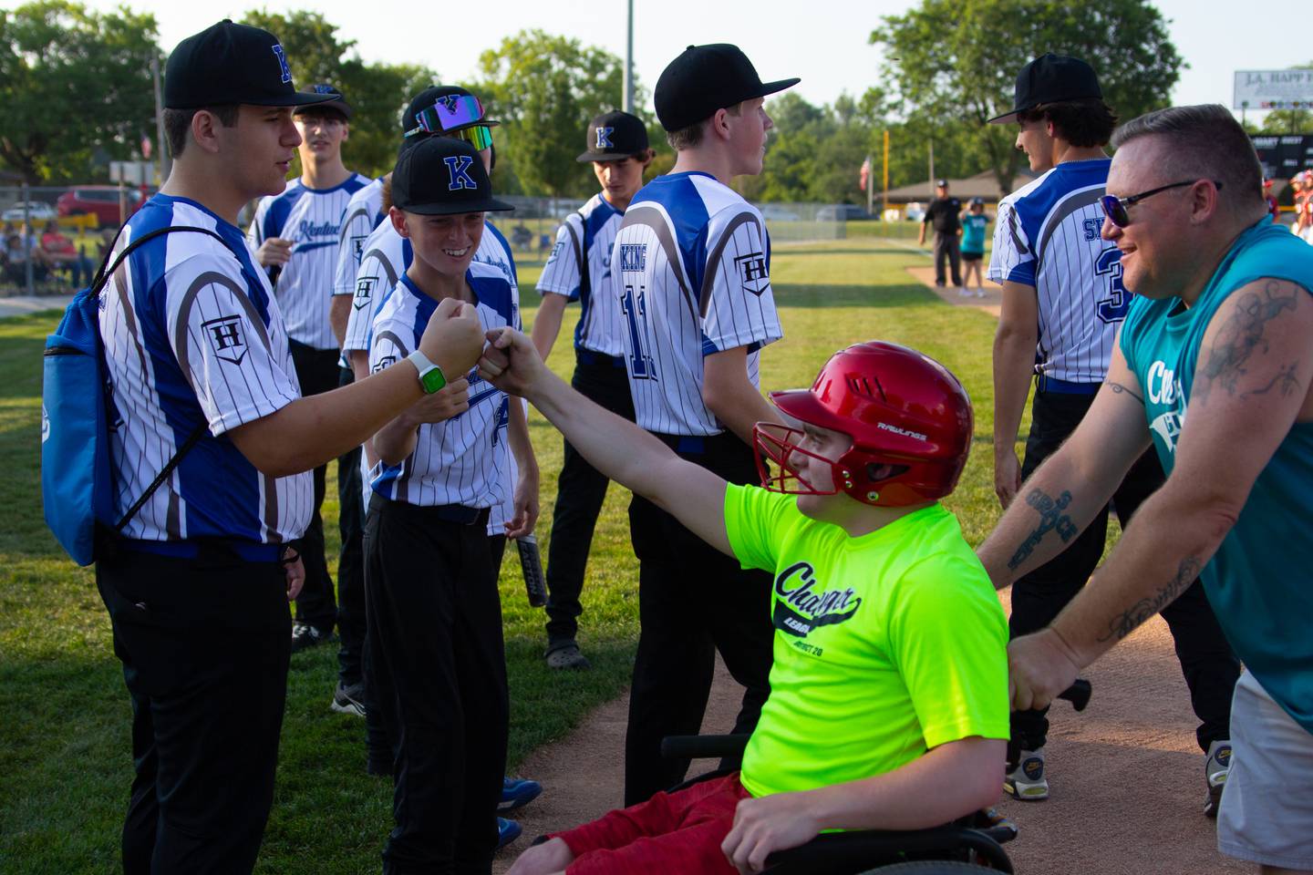 Nicholas Stacy fist bumps senior league player on Friday, July 12, 2024 at Washington Park in Peru.