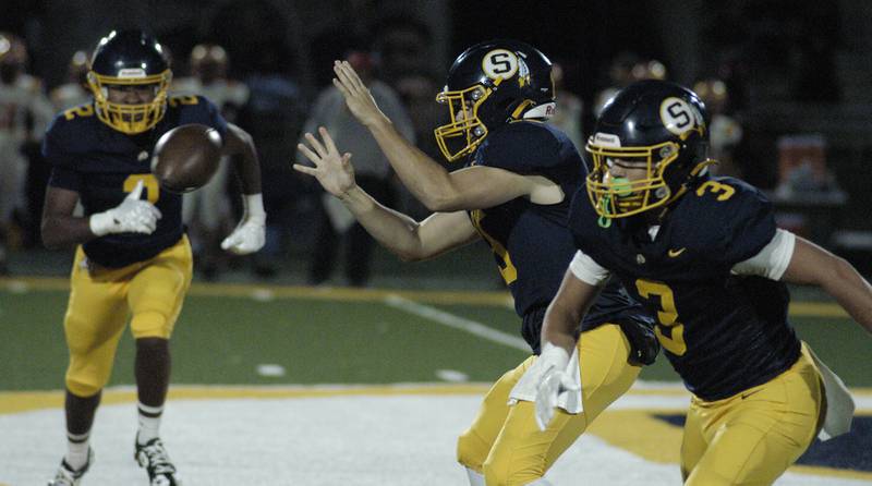 Sterling QB Drew Nettleton takes a snap as Kaedon Phillips and Cobey Shipma move into position.  Action took place on Friday, October  18th, 2024 in Sterling.