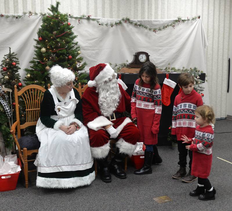 Santa and Mrs. Claus chat with the Orellana family during Erie's Hometown Holidays on Saturday, Dec. 2, 2023. Pictured are Melody, 10, Oliver, 6, and Georgia, 2. Santa and Mrs. Claus visited with kids and posed for photos at the Erie Fire Station during the event.
