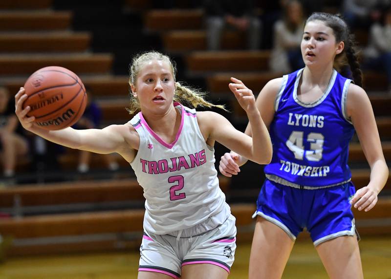 Downers Grove North's Hope Sebek (2) saves the ball from going out of bounds after it was tapped away by Lyons Township's Ann Stephens (43) during a game on Jan. 30, 2024 at Downers Grove North High School in Downers Grove .