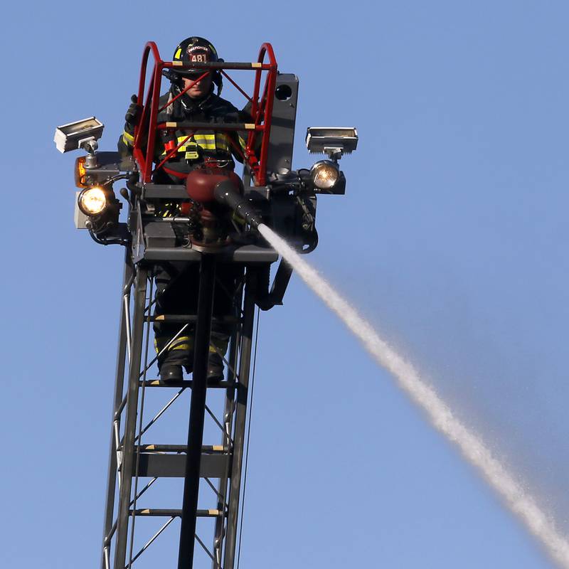 A firefighter battle a house fire in the 300 block of Lincoln Avenue in Woodstock Monday, Oct. 9, 2023, after an explosion following suspected gas leak in the area.