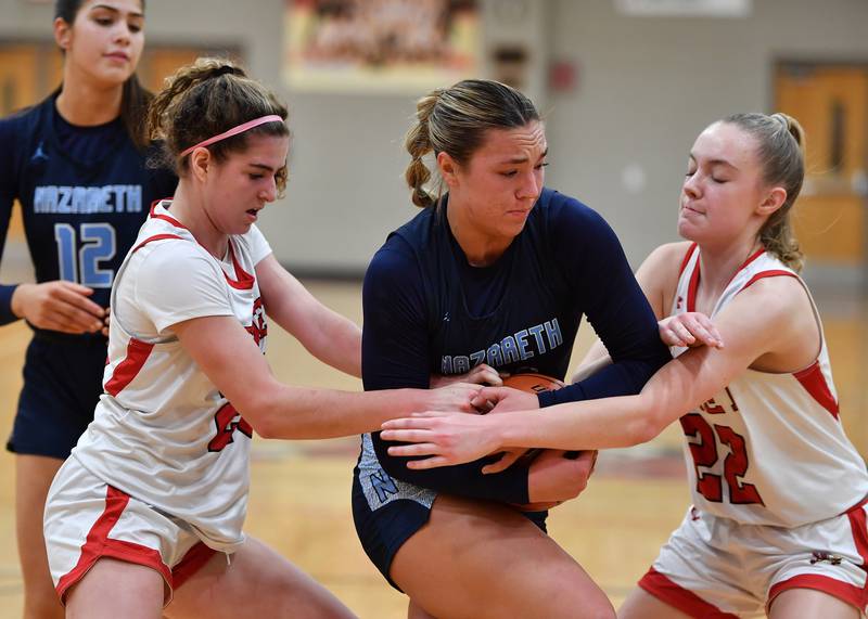 Nazareth's Olivia Austin (middle) protects the ball from Benet's Shannon Earley and Bridget Rifenburg (22) during a game on Dec. 13, 2023 at Benet Academy in Lisle.
