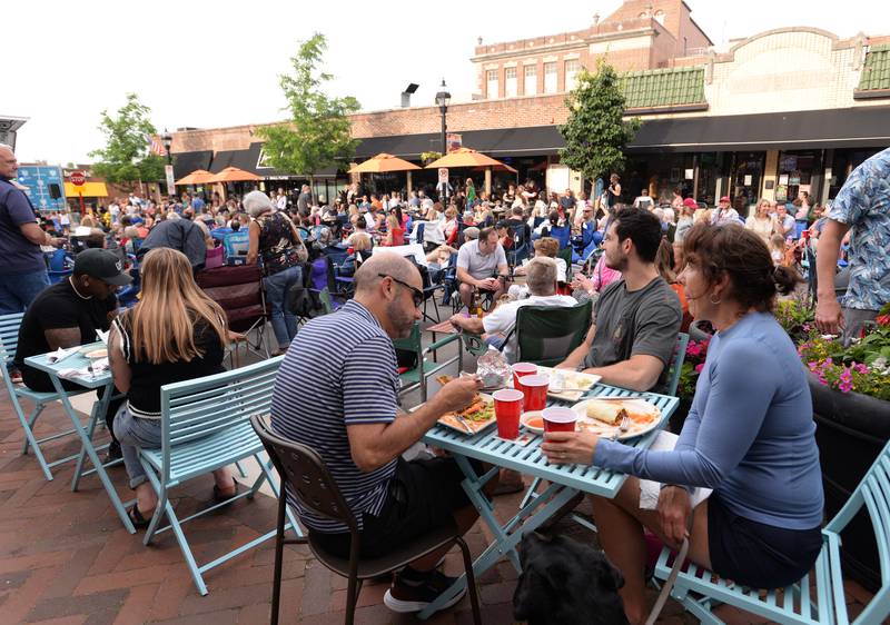 Families including (left-right) Nick, Peter and Chris Kalivas enjoy a meal outside Santa Fe during a concert held downtown Glen Ellyn Friday June 8, 2024.