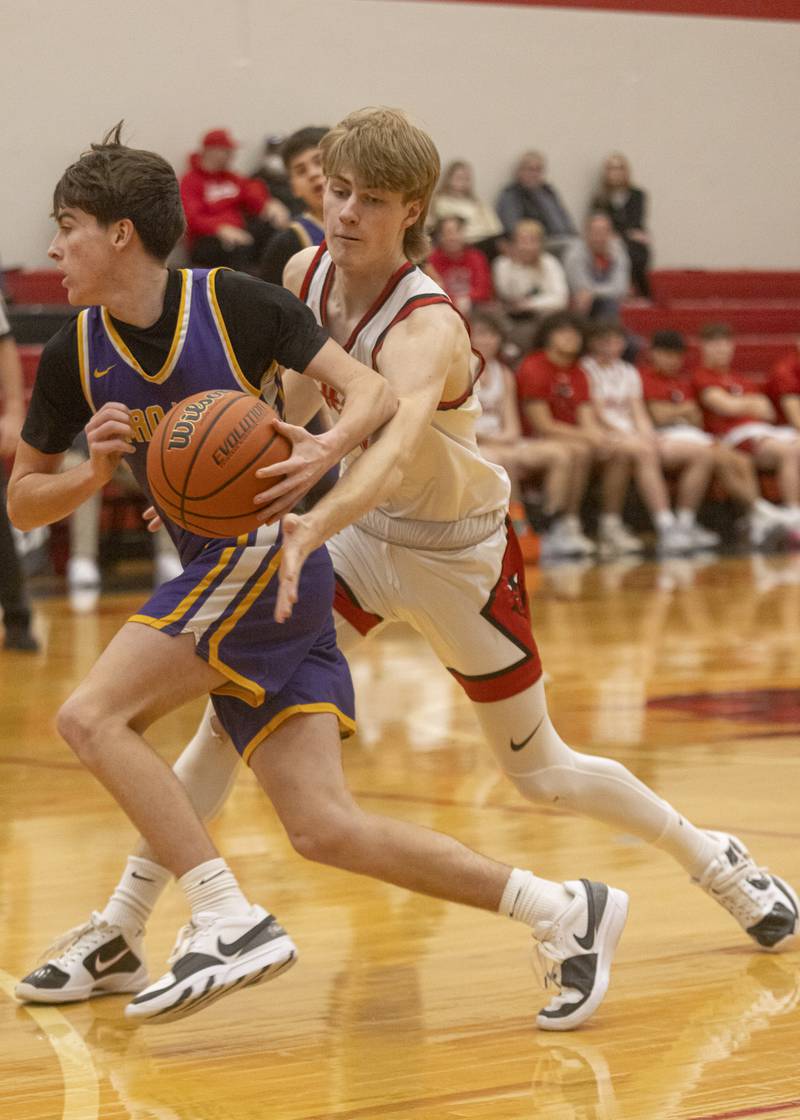 Hall's Max Bryant attempts to strip the ball from the Trojans during the IHSA Class 2A quarterfinal at Hall High School on Feb. 19, 2024.