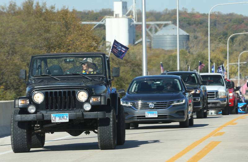 A pickup truck waves Trump 2024 flags while leading others in the Trump Caravan over the Illinois Route 178 on Saturday, Oct. 19, 22024 in Utica.