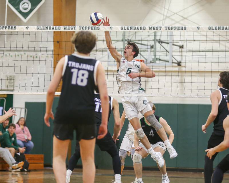 Glenbard West's Jack Anderson (6) tips the ball over the net during volleyball match between Downers Grove North at Glenbard West.  April 2, 2024.