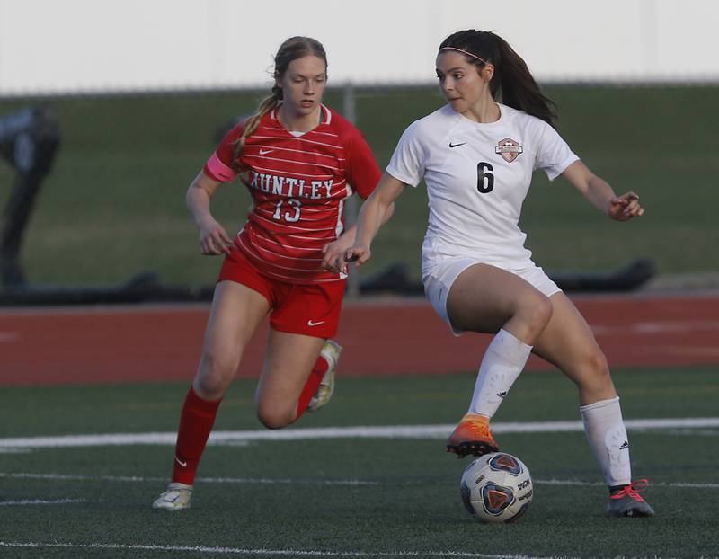 McHenry's Becca D'Agostino controls the ball in front of Huntley’s Morgan McCaughn during a Fox Valley Conference soccer match Thursday, April 13, 2023, at Huntley High School.