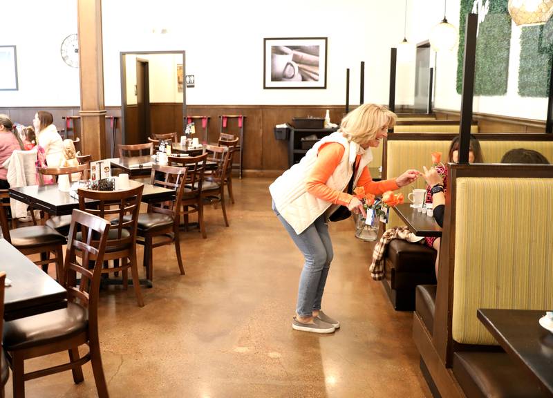 Random Acts Matter volunteer Sharon LeGare (left) hands out orange roses at the Brunch Cafe in St. Charles as part of Random Acts of Kindness Week on Wednesday, Feb. 14, 2024.