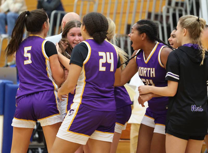 Downers Grove North’s Ann Stephens is mobbed by her team after the game winning shot against Lyons Township during the girls varsity basketball game on Tuesday, Jan. 16, 2024 in La Grange, IL.