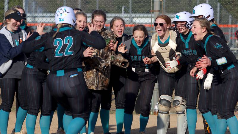 Woodstock North’s Jo Jo Vermett is greeted at the plate on a home run in varsity softball at Crystal Lake Central Friday.