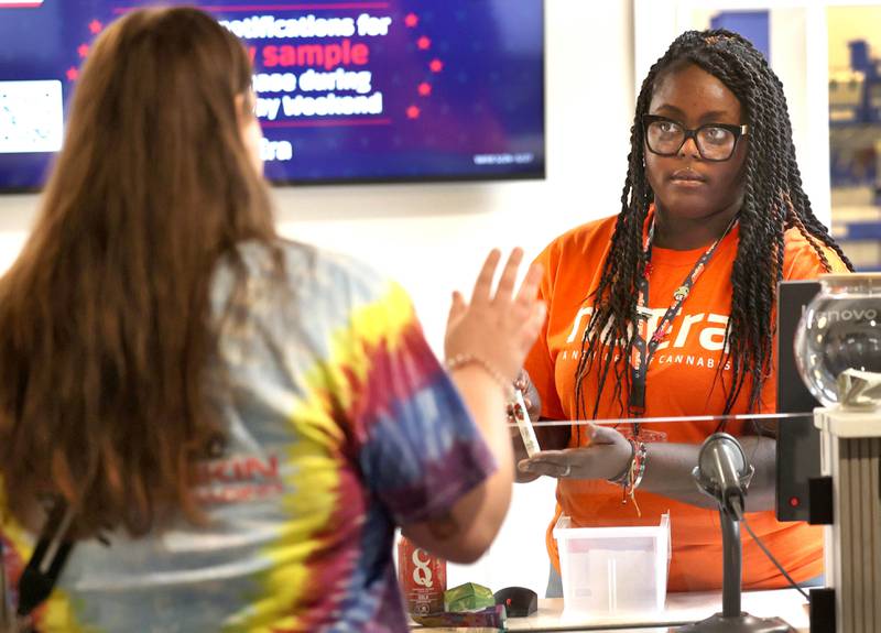 Asia Miller, (right) a budtender at nuEra cannabis dispensary, answers some questions for customer Emma Ingram, from DeKalb, Thursday, May 23, 2024, about her purchase at the new business in DeKalb. Thursday was opening day for the dispensary which is located at 818 West Lincoln Highway, in the Junction Shopping Center.