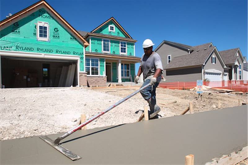 Benjamin Mora of Huntley works smoothing out the sidewalk in front of a home being developed by Ryland Homes at the Talamore Subvision in Huntley.