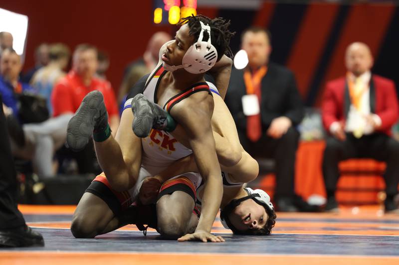 Riverside’s Edgar Mosquera wraps his legs around Rock Island’s Truth Vesey in the 113-pound Class 2A state championship match on Saturday, Feb. 17th, 2024 in Champaign.