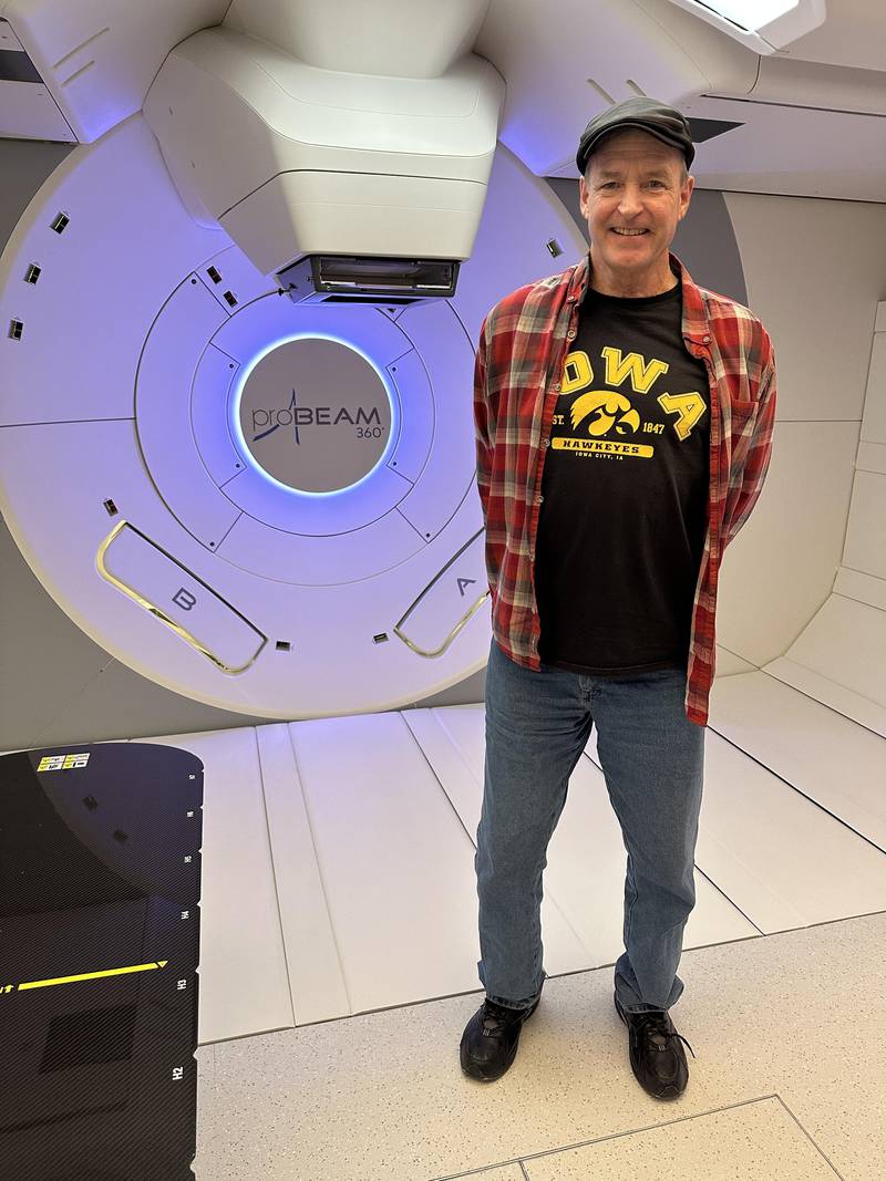 Tim Scott, of Princeton, stands next to OSF's proton beam radiation therapy machine.