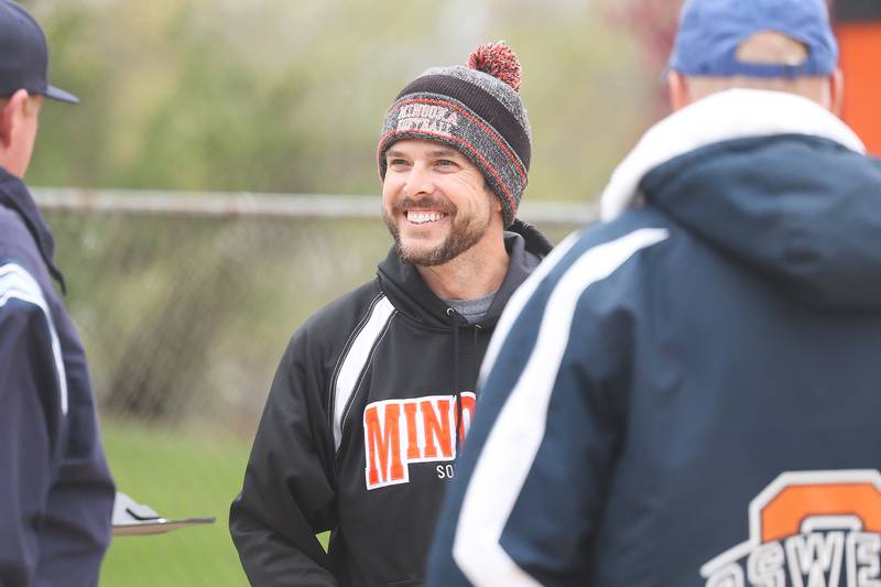 Minooka head coach Mark Brown meets with the umpire beofre the game against Oswego on Wednesday, April 17, 2024 in Minooka.