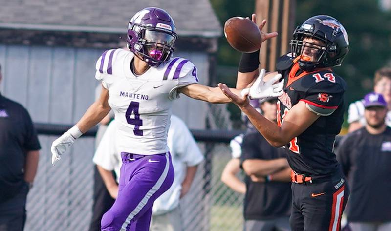 Sandwich Caleb Jones (14) intercepts a pass intended for Manteno's Kyle Mc Cullough (4) and runs it back for a touchdown against Manteno during a football game at Sandwich High School on Saturday, Aug 26, 2023.