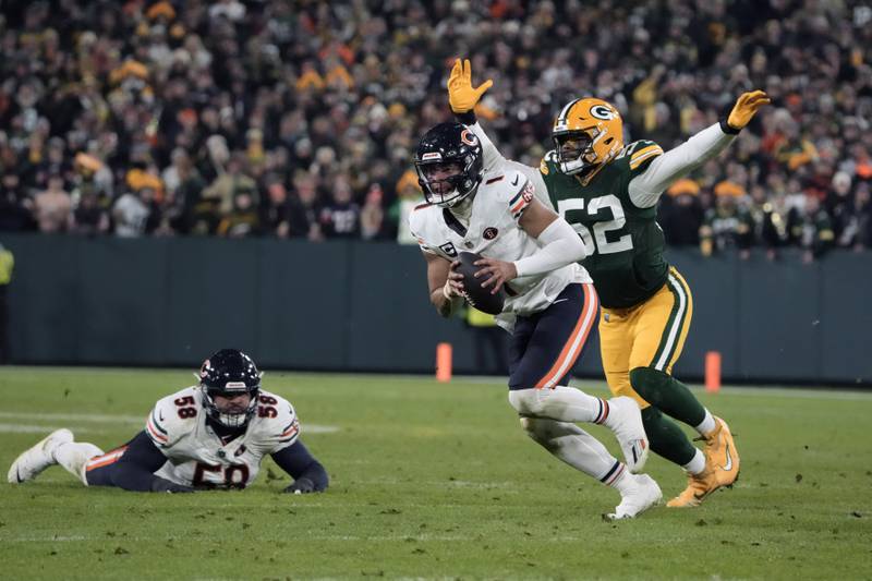 Chicago Bears quarterback Justin Fields (1) scrambles under pressure from Green Bay Packers linebacker Rashan Gary (52) as Bears offensive tackle Darnell Wright (58) watches during the second half Sunday, Jan. 7, 2024, in Green Bay, Wis.