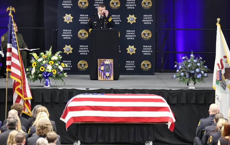 DeKalb County Sheriff Andy Sullivan becomes emotional as he talks about colleague Deputy Christina Musil near her flag-draped casket Thursday, April 4, 2024, during her visitation and funeral in the Convocation Center at Northern Illinois University. Musil, 35, was killed March 28 while on duty after a truck rear-ended her police vehicle in Waterman.
