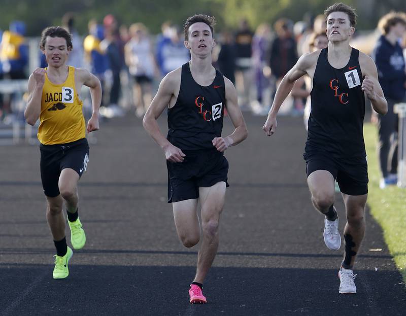 Jacobs’ Andrew Beyer, tries to catch Crystal Lake Central’s Karson Hollander and Aiden Shulfer as they race to the finish line of the 3200 meter run Friday, April 21, 2023, during the McHenry County Track and Field Meet at Cary-Grove High School.