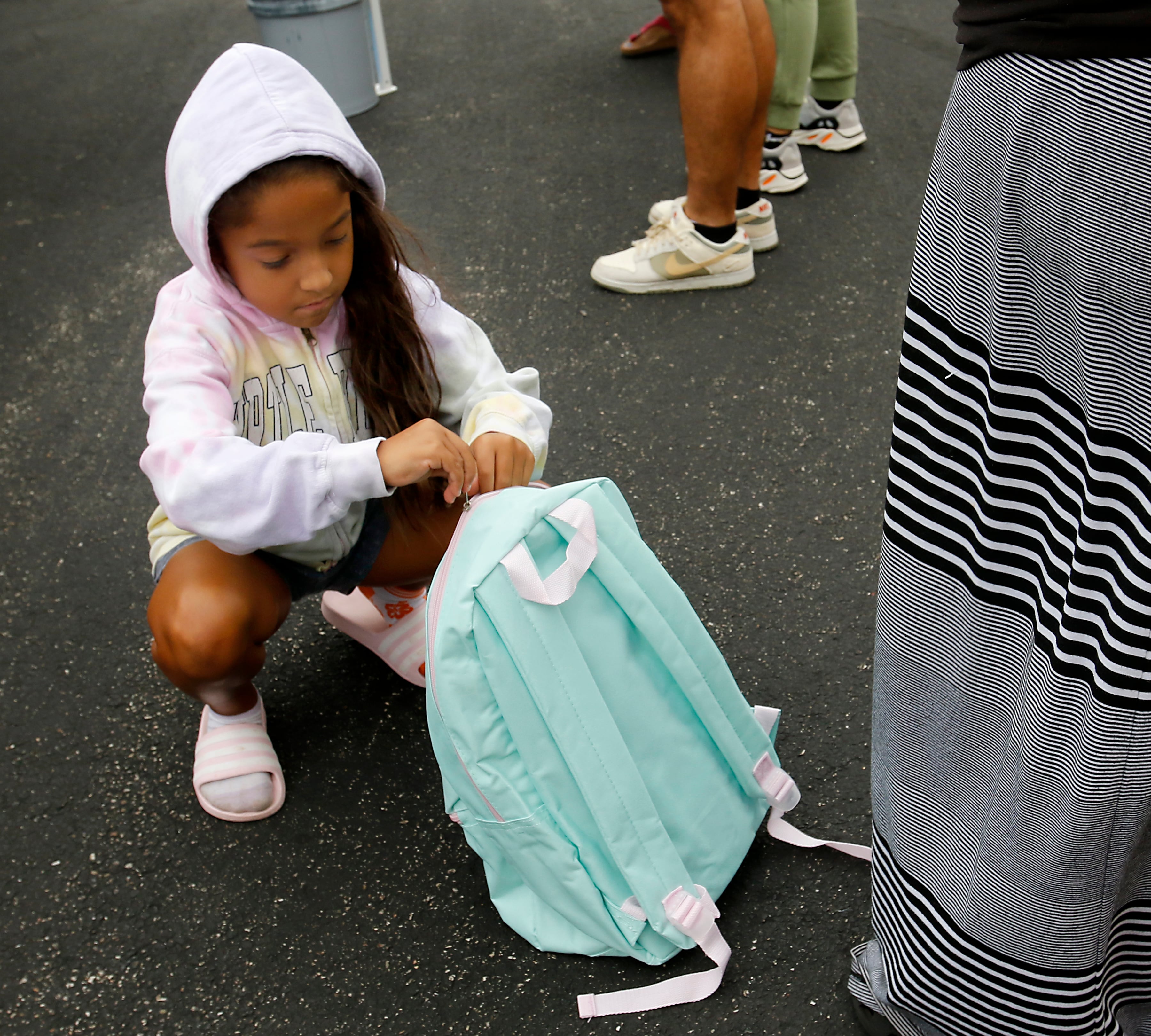 Tudy Villalobos, 8, opens her new backpack during a Woodstock School District 200 Back to School Coming to You event at Northwood Middle School on Tuesday, Aug. 6, 2024. The location was one of twelve stops on the tour that gave out backpacks and school supplies, provided registration help and computer repair.