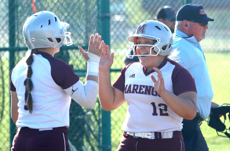 Marengo’s Emily White, right, is all smiles after coming around to score against Richmond-Burton in varsity softball at Marengo Monday.