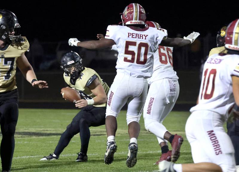 Morris' Devin  Perry and Omarion Miller close in for a sack of Sycamore's Burke Gautcher during their game Friday, Oct. 18, 2024, at Sycamore High School.