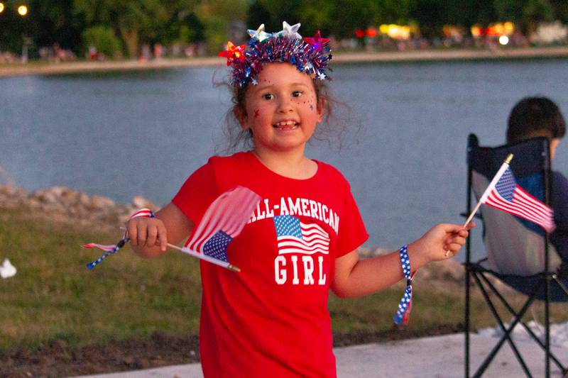 Amelia Owens of Mendota waves American Flags on Saturday, June 29, 2024 at Lake Mendota.