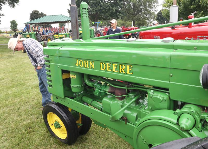 Visitors check out some of the vintage tractors Saturday, July 16, 2022, at the Waterman Lions Summerfest and Antique Tractor and Truck Show at Waterman Lions Club Park.