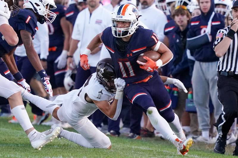 Oswego’s Theodore Manikas (11) runs after the catch against Joliet Catholic's Michael Jaworski (35) during a football game at Oswego High School on Friday, Sep 6, 2024.