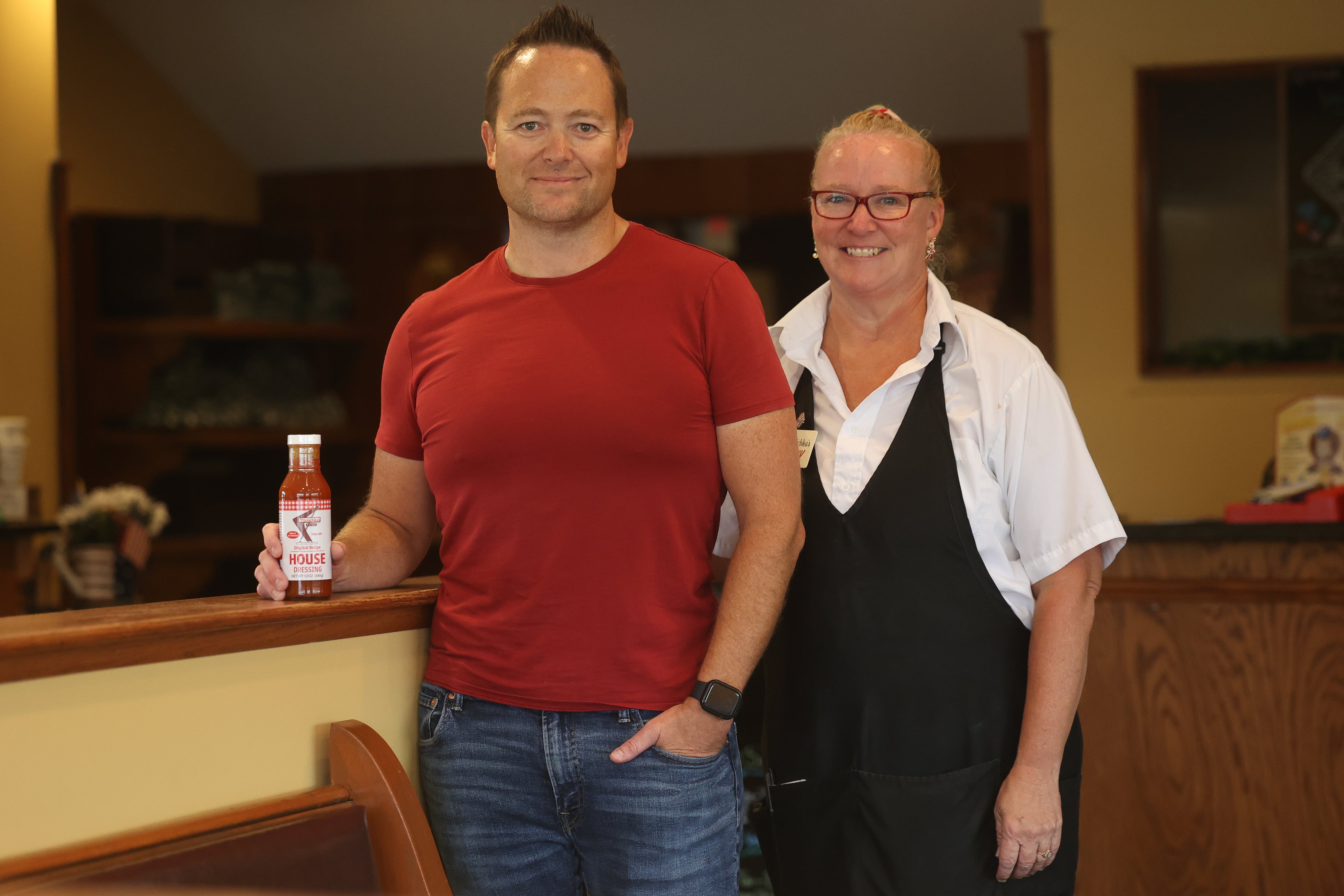 Merichka’s owner Joe Zdralevish III holds a bottle of their popular house dress while standing with his cousin Becky Velasquez who also works at the restaurant on Tuesday, Aug. 6, 2024 in Joliet.