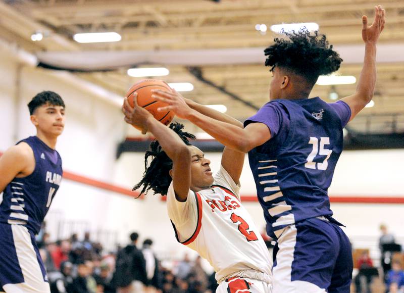 Yorkville's Michael Dunn (2) tries to find some room against Plano defender Amari Bryant (25) during a varsity basketball game at Yorkville High School on Tuesday, Dec. 19, 2023.