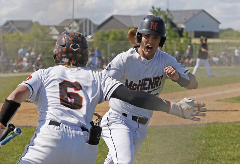 McHenry's Kyle Maness celebrates with his teammate, Jack Stecker, after Maness scored the go ahead run on a passed ball during a Class 4A Hampshire sectional baseball game against Hampshire on Wednesday, May 29, 2024, at the Hampshire High School.