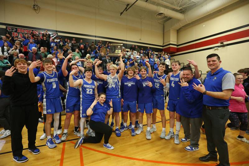 Members of the Princeton boys basketball team hoist the Class 2A Regional plaque after defeating Morrison during the Class 2A Regional final game on Friday, Feb. 23, 2024 at Erie-Prophetstown High School. Players and coaches held up the number three for three-peat Regional champions.