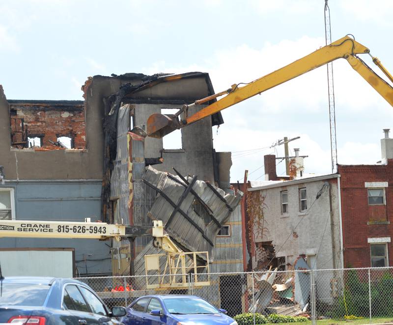 An excavator takes down a portion of the back of an apartment building at 406 E. Third St. in Sterling on Tuesday, July 11, 2023. The building was destroyed by the July 7 blaze and one man is presumed dead.