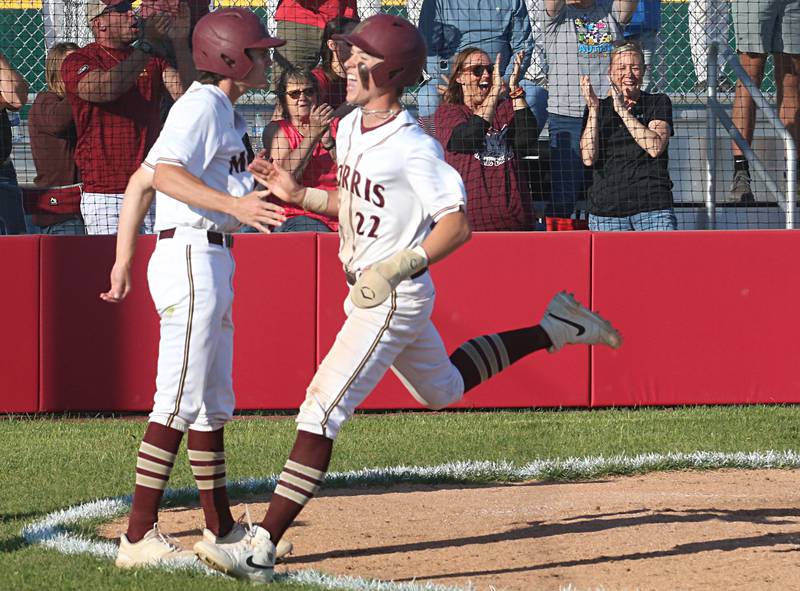 Morris's Brett Bounds hi-fives teammate AJ Zweeres after scoring a run against L-P during the Class 3A Regional semifinal game at Huby Sarver Field in La Salle.