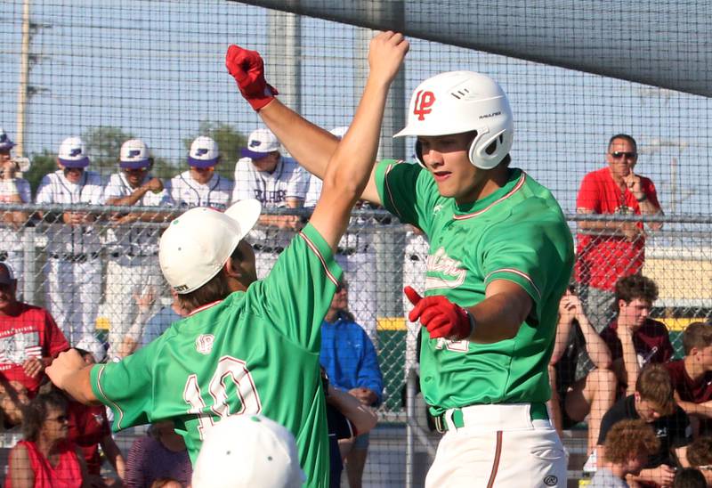 L-P's Aieden Wenskunas and Brendan Boudreau leap in the air after scoring a run against Morris during the Class 3A Regional semifinal game at Huby Sarver Field in La Salle.
