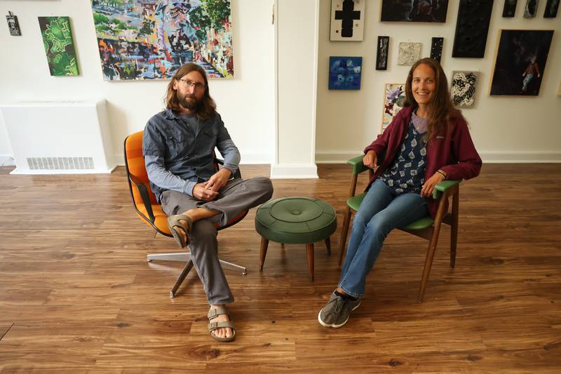 Erik Ohrn and his wife Eryn Blaser pose in front of their work on display at the Strange and Unusual Gallery in Downtown Joliet on Sunday, Sept. 17.
