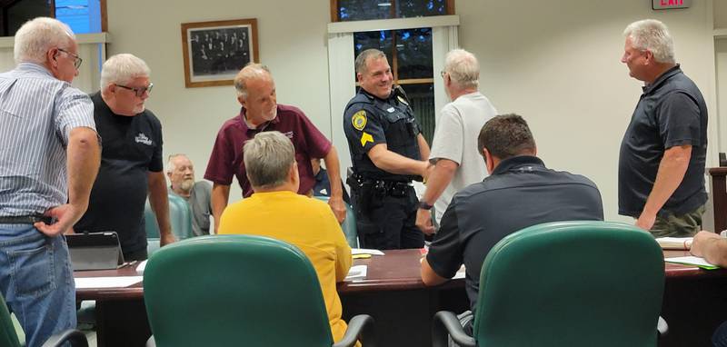 Spring Valley native Matt Stank (center) is congratulated by the Spring Valley City Council members after being officially promoted to the rank of sergeant of the city's police department.