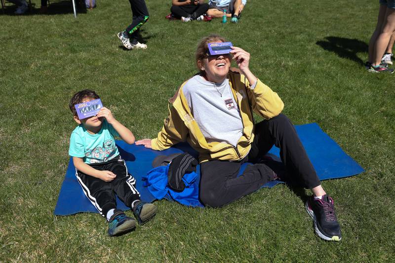 Nancy Carroll and her grandson Rayner, 4, watch the eclipse with special glasses provided by JJC at the Joliet Junior College solar eclipse viewing event on Monday, April 8, 2024 in Joliet.